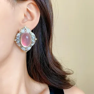 Primo piano dettagliato di eleganti orecchini vintage con pietra rosa e cristalli