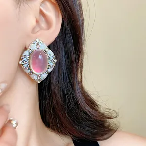 Elegante primo piano di orecchini vintage con pietra rosa e cristalli colorati
