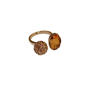 Elegant gold-tone open ring featuring an oval amber stone and a pavé crystal sphere