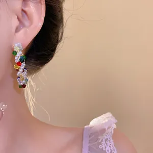 Elegante primo piano di orecchini a cerchio con perle di vetro colorate su modella