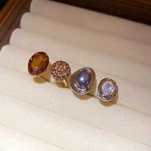 Macro view of four vintage palace style open rings with various crystal and pearl centers