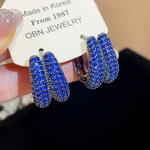 Macro view of blue zircon hoop earrings with a sparkling pave setting