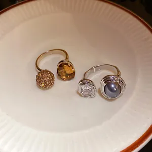 Detail view of vintage palace style open rings with various gemstone and pearl accents