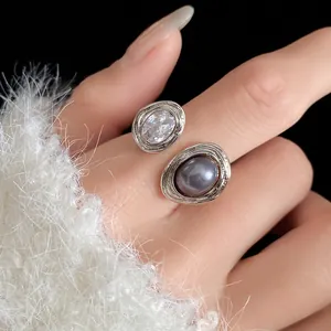 Close-up of vintage style open ring with rhinestone and grey pearl on white fuzzy sweater