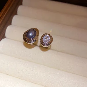 Detailed macro shot of a vintage oval open ring featuring a black pearl and clear crystal.