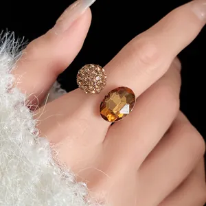 Detailed close-up of vintage amber oval gemstone and crystal pave ball open ring design