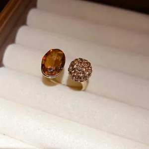 Detailed view of vintage gold open ring featuring oval amber stone and crystal ball