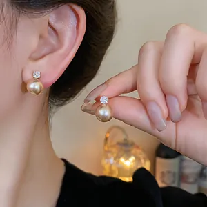 Close-up detail of vintage champagne pearl earrings with sparkling zircon studs on ear