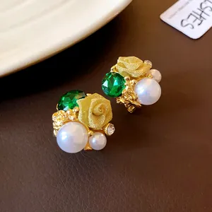 Vue détaillée des boucles d'oreilles fleur rétro française avec pierre verte et perle.