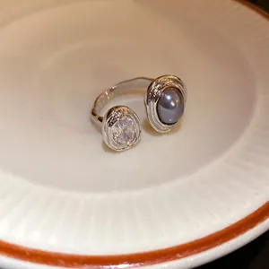 Detailed macro view of vintage silver open ring featuring zircon and grey pearl inlay
