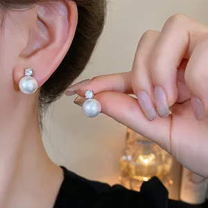 Detailed close-up of elegant pearl stud earrings with sparkling zircon inlay for women