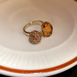 Macro detail of vintage open ring with amber oval gemstone and crystal pave ball ornament