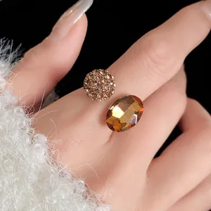 Close-up detail of elegant oval amber gemstone and crystal pave ball on open ring