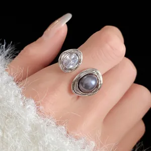 Macro detail of a vintage style open ring featuring oval cubic zirconia and a grey stone