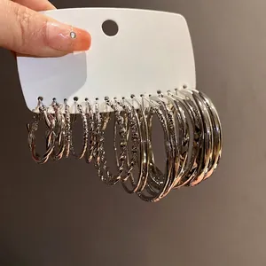 Set of metallic geometric hoop earrings in various textures and sizes.