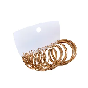 Set of elegant gold geometric hoop earrings with twisted and smooth textures on white card