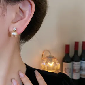 Close-up of elegant vintage style zircon pearl earrings worn by a model in soft light