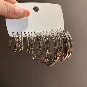Close-up of a silver needle geometric twisted hoop earring set on a white display card