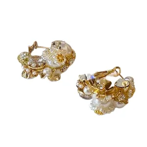 Elegant gold-tone flower hoop earrings with white pearls and sparkling crystal accents