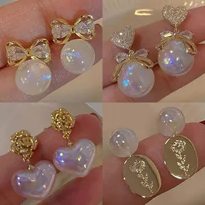 Close-up collage of elegant mermaid pearl earrings with bowknot and heart details.