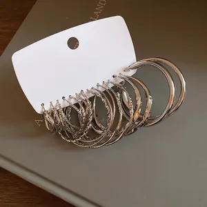 Close-up of silver geometric hoop earring set with various textures on card