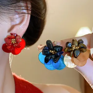 Close-up detail of retro shell and tiger eye stone flower stud earrings in various colors.