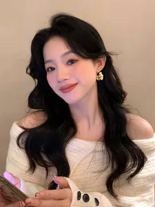 Close-up of elegant flower pearl earrings with sparkling crystals on an Asian model's ear