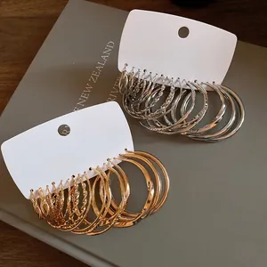 Variety set of gold and silver geometric hoop earrings with twisted and smooth textures.