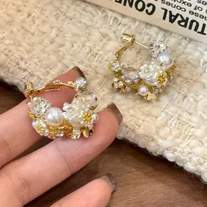 Detailed macro view of elegant floral earrings with pearls and crystals on gold plating