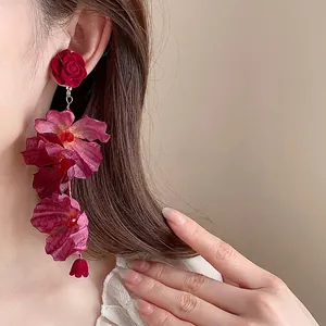 Elegant long rose flower drop earrings with fabric petals and silver needles on model