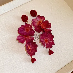 Elegant long floral pendant earrings featuring layered magenta fabric petals and red roses