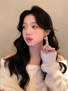 Elegant close-up shot of sparkling flower-shaped pearl earrings worn by an Asian model