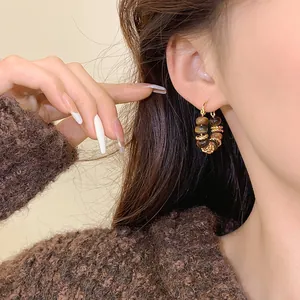 Elegant gold-plated tiger eye bead hoop earrings shown on model for Maillard style