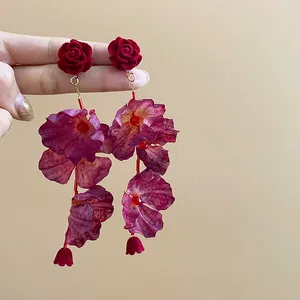 Detailed view of red velvet rose and purple burgundy fabric petal long dangle earrings.