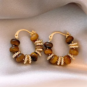 Macro view of vintage gold plated hoop earrings featuring natural brown tiger eye beads