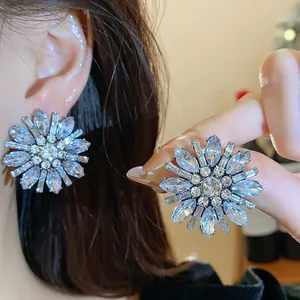 Vista dettagliata di orecchini a fiore con strass indossati all'orecchio.