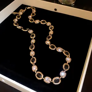 Detailed macro view of an elegant gold necklace with black and white oval crystals