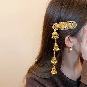 Elegant gold floral hair clip featuring sparkling rhinestones and dangling bell tassels