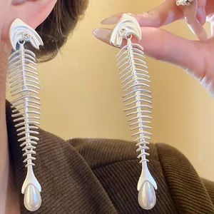 Nahaufnahme der kreativen Fischgräten-Ohrhänger aus Silber mit eleganten Perlen