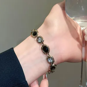 Close-up of a vintage oval bracelet with black and clear stones on a wrist