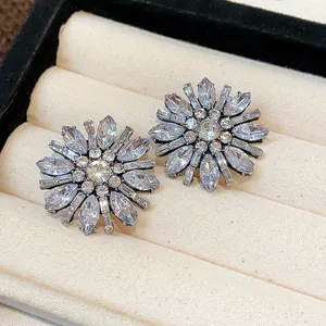 Primo piano di orecchini a forma di fiore con strass scintillanti in un portagioie