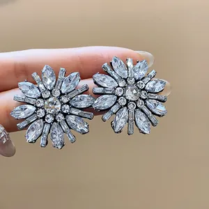 Dettaglio macro di orecchini a lobo a fiore con cristalli brillanti e pietre a taglio