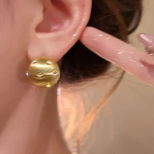 Luxury 18K gold plated brushed elliptical stud earrings with zircons on model ear