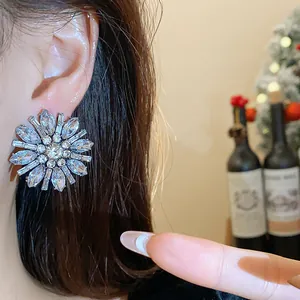 Dettaglio ravvicinato dell'orecchino a fiore con strass scintillanti indossato sul lobo