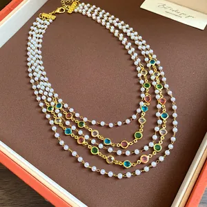 Dettaglio della collana di perle di vetro multistrato con gemme colorate in stile vintage.