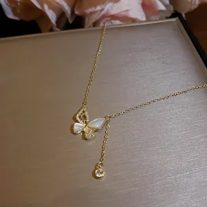 Detail van vlinderhanger met sprankelende zirkonia en witte inleg van schelp