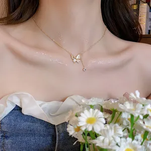 Elegante vergulde zirkonia vlinder hanger ketting om de nek van een Aziatisch vrouwelijk model