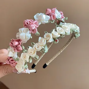 Elegante Haarbänder mit handgefertigten Stoffblumen in Rosa und Weiß für Damen und Mädchen.