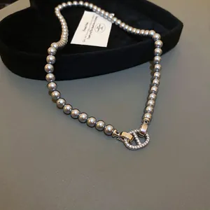 Elegant grey pearl necklace featuring a sparkling rhinestone-encrusted clasp detail