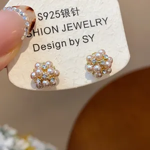 Close-up of elegant S925 silver needle earrings with pearls and rhinestones flower design